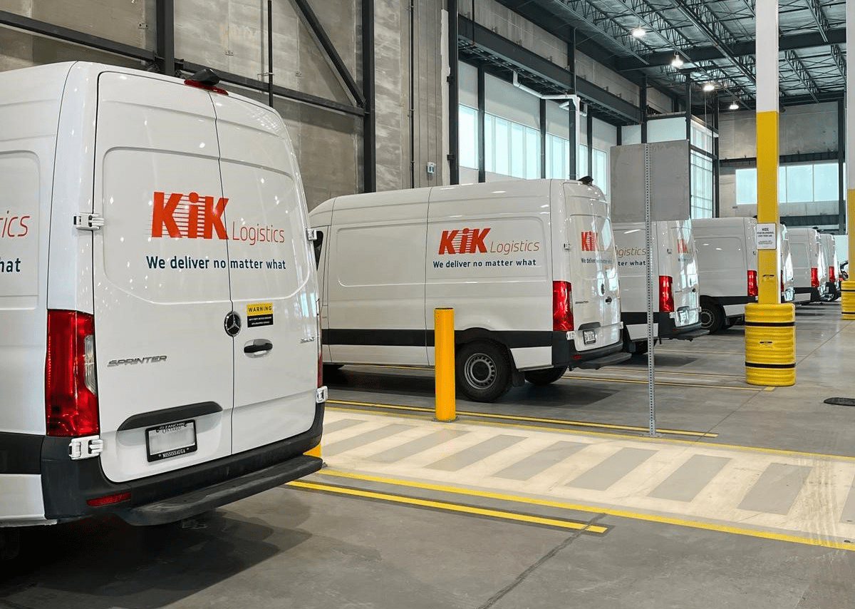 A row of vans parked in a warehouse.